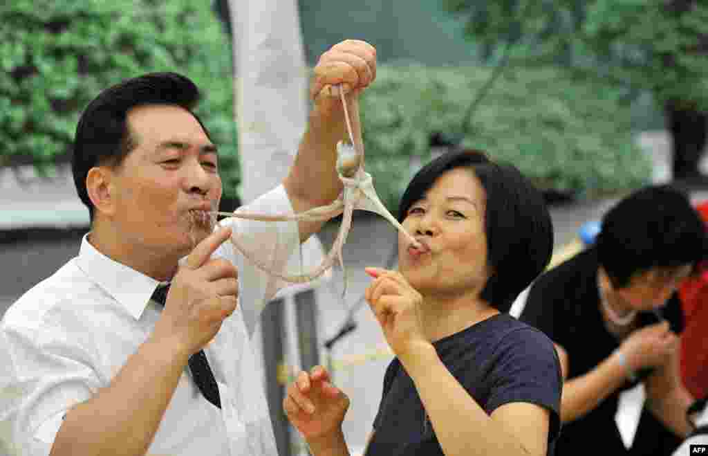 A South Korean man and a woman eat a live octopus during an event to promote a local food festival in Seoul.