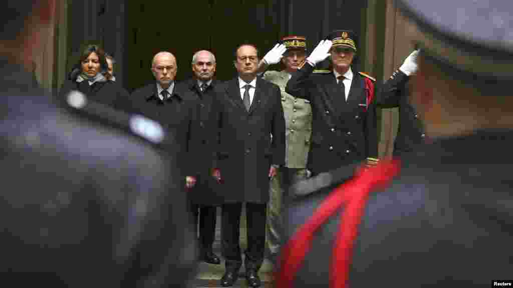 Le président français François Hollande, centre, le ministre de l'Intérieur Bernard Cazeneuve, deuxième à gauche, le maire de Paris Anne Hidalgo, à gauche, et le préfet de police, Bernard Boucault, à droite, observent une minute de silence à la Préfecture de Paris à Paris, le 8 janvier 2015.