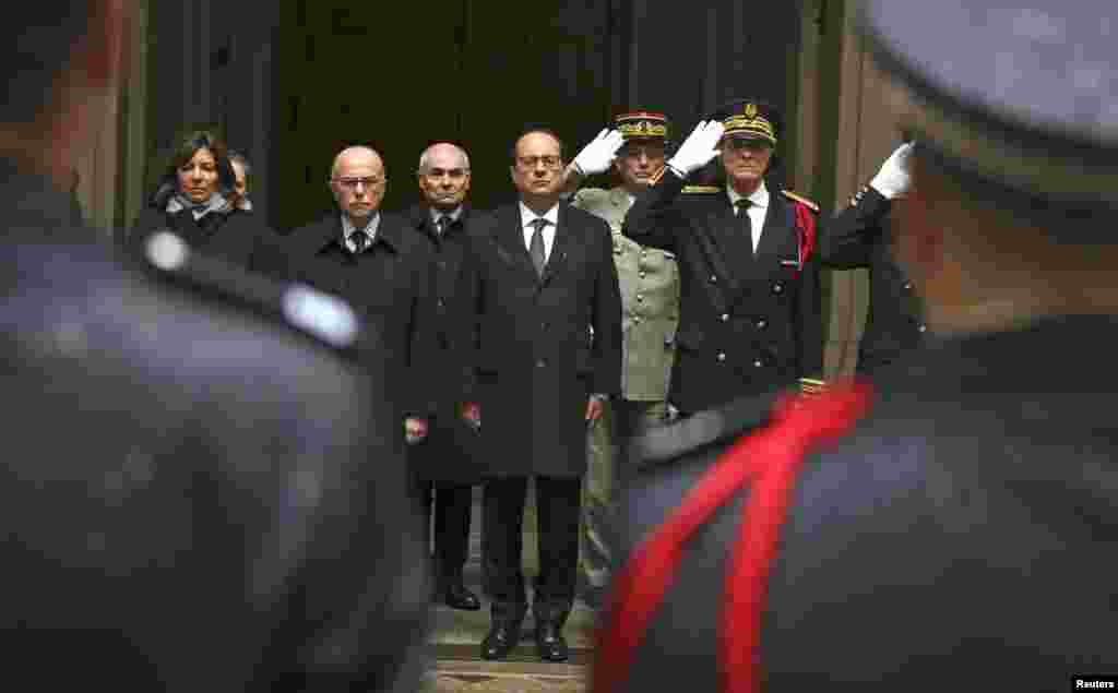 French President Francois Hollande, center, Interior minister Bernard Cazeneuve, second from left, Paris mayor Anne Hidalgo, left, and Paris police prefect Bernard Boucault, right, stand for a minute of silence at Paris Prefecture in Paris, Jan. 8, 2015.