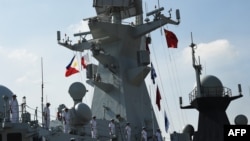 Des marins chinois à bord de la frégate de missiles guidés Wuhu (539) en formation lors de l'accostage au port international de Manille le 17 janvier 2019. 