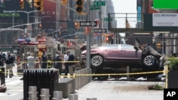 A car rests on a security barrier in New York's Times Square after driving through a crowd of pedestrians, injuring at least a dozen people, May 18, 2017. 