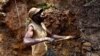 A miner digs out soil which will later be filtered for traces of cassiterite, the major ore of tin, at Nyabibwe mine, in eastern Congo, Aug. 7, 2012. (AP Photo/Marc Hofer)