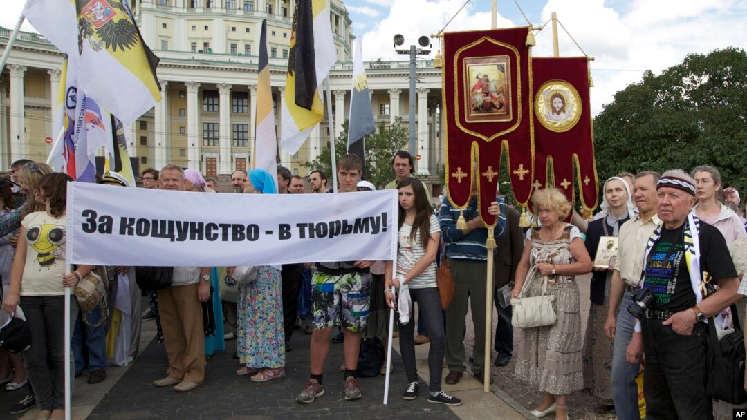 FILE - Believers take part in a rally in support of the Russian Orthodox Church, in Moscow, Russia, July 22, 2012. Their banner reads "Jail for blasphemy!"