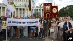 FILE - Believers take part in a rally in support of the Russian Orthodox Church, in Moscow, Russia, July 22, 2012. Their banner reads "Jail for blasphemy!"