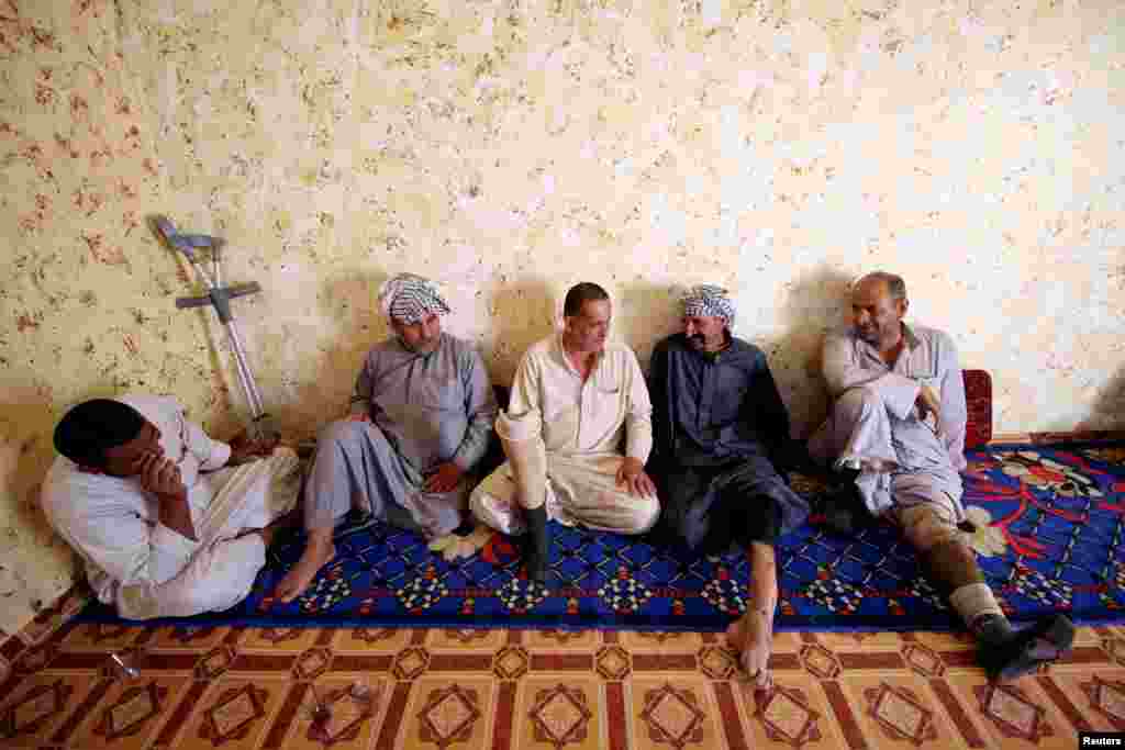 Basra&#39;da bastığı mayının patlaması yüzünden sakat kalan Iraklı Rafet, arkadaşlarıyla sohbet ediyor.