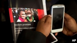 FILE - A journalist holds a copy of a report into the state of press freedom in Kenya, at a press conference to launch the report in Nairobi, Kenya, July 15, 2015.