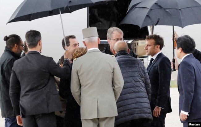 French President Emmanuel Macron greets hostages who were freed by special forces in Burkina Faso upon their arrival at the Villacoublay airport, in Velizy-Villacoublay, France, May 11, 2019.