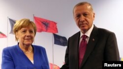 FILE - Turkish President Tayyip Erdogan meets with Germany's Chancellor Angela Merkel in Brussels, Belgium, July 11, 2018. 