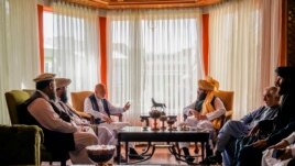 In this handout photograph released by the Taliban, former Afghan President Hamid Karzai, center left, senior Haqqani group leader Anas Haqqani, center right, Abdullah Abdullah, second right, head of Afghanistan's National Reconciliation Council.