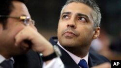 FILE - Canadian Al-Jazeera English journalist Mohammed Fahmy, listens to his lawyer, Khaled Abou Bakr during his retrial in a courtroom, of Tora prison, in Cairo, Egypt, June 1, 2015.