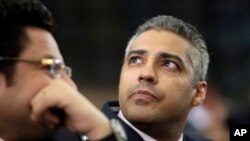 Canadian Al-Jazeera English journalist Mohamed Fahmy, listens to his lawyer, Khaled Abou Bakr, during his retrial in a courtroom, of Tora prison, in Cairo, Egypt, June 1, 2015.