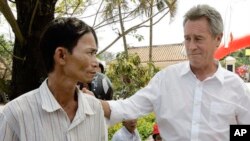 In this Saturday, March 15My Lai Massacre survivor Do Ba, left, stands with former U.S. Army officer Lawrence Colburn, right, in this 2008 picture.