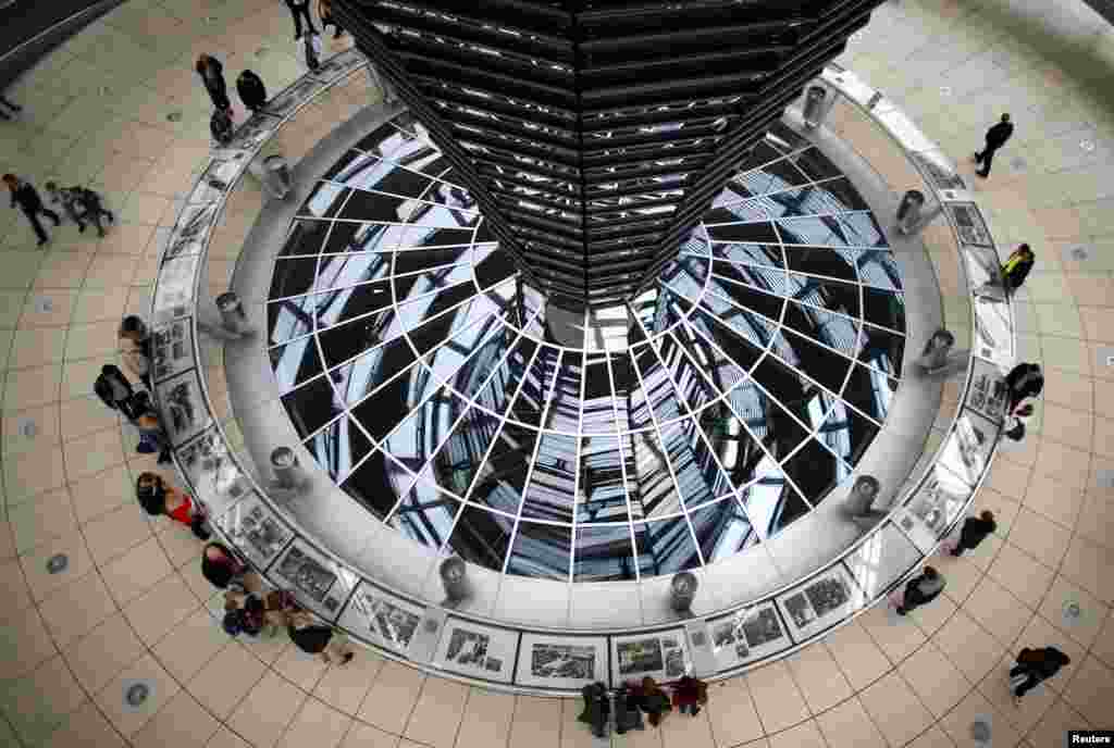 People walk inside the dome of the Reichstag building, the seat of the German lower house of parliament Bundestag in Berlin. 