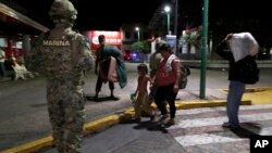 Yon militè meksiken ki kanpe devan yon fanmi imigran yo mete deyò sou plas Tapachula o Mekzik mèkredi 29 me 2019 la. 