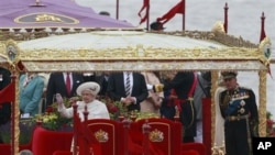 Ratu Elizabeth II dan suaminya, Pangeran Phillip dalam perayaan iring-iringan perahu di sungai Thames, London hari Minggu.