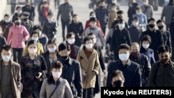 People wearing protective face masks commute amid concerns over the new coronavirus disease (COVID-19) in Pyongyang, North Korea March 30, 2020, in this photo released by Kyodo. Mandatory credit Kyodo/via REUTERS/File Photo