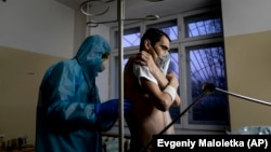 Лікар у захисному костюмі перевіряє пацієнта з коронавірусом. Житомирська область, 28 квітня 