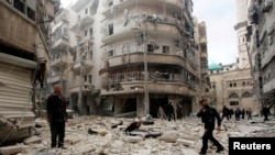 FILE -- Men inspect damage at site of barrel bomb attack by forces loyal to Syria's President Bashar al-Assad, al-Shaar neighborhood, Aleppo, February 26, 2015.