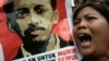 FILE - An Indonesian protester shouts slogans as she holds a poster of Munir Said Thalib during a demonstration outside the National Intelligence Agency (BIN) office in Jakarta.