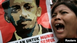 Seorang demonstran meneriakkan slogan-slogan sambil membawa poster Munir dalam sebuah demonstrasi di luar kantor Badan Intelejen Nasional, Jakarta (Foto: dok). 