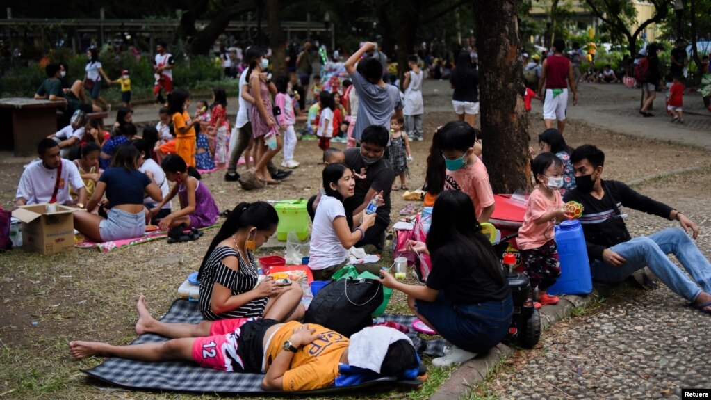 Parents and children relax at a public park, as the country's capital region loosens coronavirus disease (COVID-19) restrictions, in Quezon City, Metro Manila, Philippines, November 2, 2021. (REUTERS/Lisa Marie David)