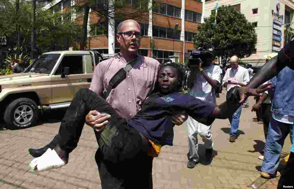 A journalist rescues a woman injured in a shootout between armed men and the police at the Westgate Shopping Center in Nairobi, Sept. 21, 2013.