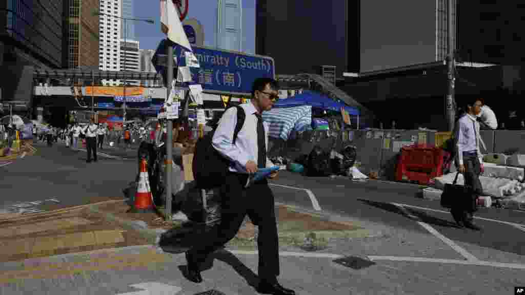 People walk to work on a main road in the occupied areas surrounding the government complex in Hong Kong, Oct. 6, 2014. 