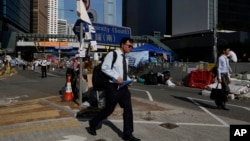 Pekerja menuju kantor di jalan utama tempat demonstrasi terjadi di Hong Kong (6/10). (AP/Kin Cheung)