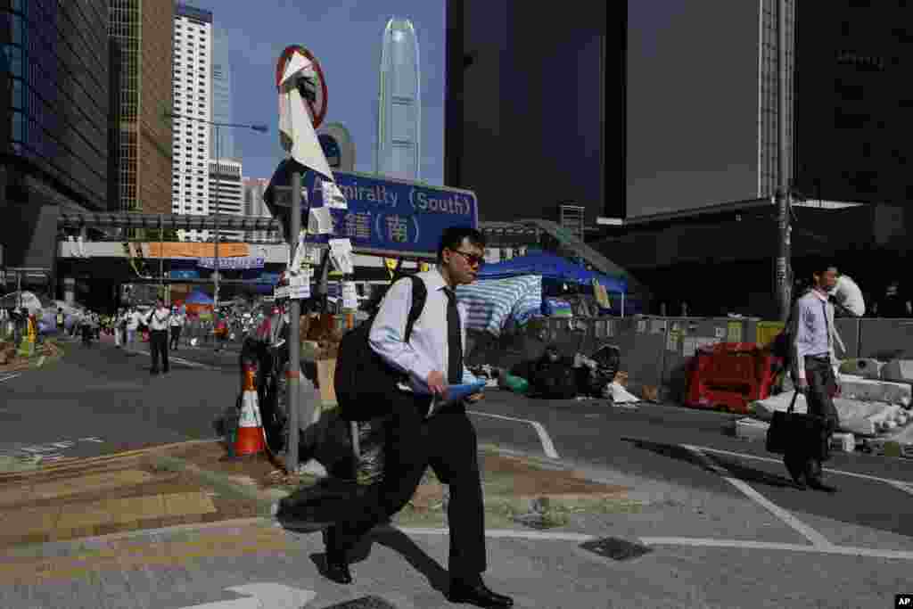 People walk to work on a main road in the occupied areas surrounding the government complex in Hong Kong, Oct. 6, 2014.