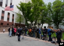 Hawaii Attorney General Doug Chin (at left, with back to camera) talks to reporters outside a federal courthouse in Seattle, May 15, 2017. A three-judge panel of the 9th U.S. Circuit Court of Appeals heard arguments Monday in Seattle over Hawaii's lawsuit challenging President Donald Trump's revised travel ban, which would suspend the nation's refugee program and temporarily bar new visas for citizens of Iran, Libya, Somalia, Sudan, Syria and Yemen.