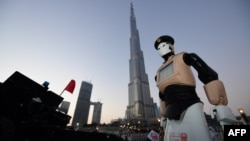 The world's first operational police robot stands at attention as they prepare a military cannon to fire to mark sunset and the end of the fasting day for Muslims observing Ramadan, in Downtown Dubai on May 31, 2017. 