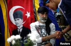 Protesters greet each other near a portrait of Mustafa Kemal Ataturk, founder of modern Turkey, at Gezi Park near Taksim Square in Istanbul, June 6, 2013.