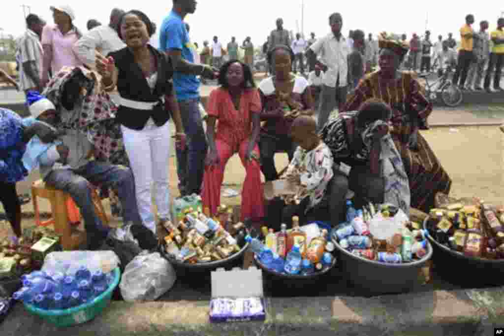 Women sell local alcohol and water at the venue of the ongoing nationwide strike following the removal of a fuel subsidy by the government in Lagos, Nigeria, Friday, Jan. 13, 2012. Unions in Nigeria announced Friday a weekend pause in a paralyzing natio