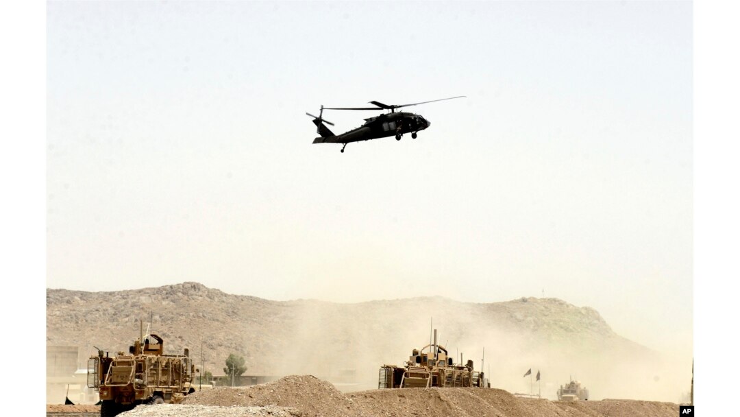 FILE - A US military helicopter flies over the site of a suicide bomb that struck a NATO convoy in Kandahar south of Kabul, Afghanistan, Aug. 2, 2017.