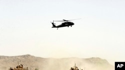 FILE - A US military helicopter flies over the site of a suicide bomb that struck a NATO convoy in Kandahar south of Kabul, Afghanistan, Aug. 2, 2017.