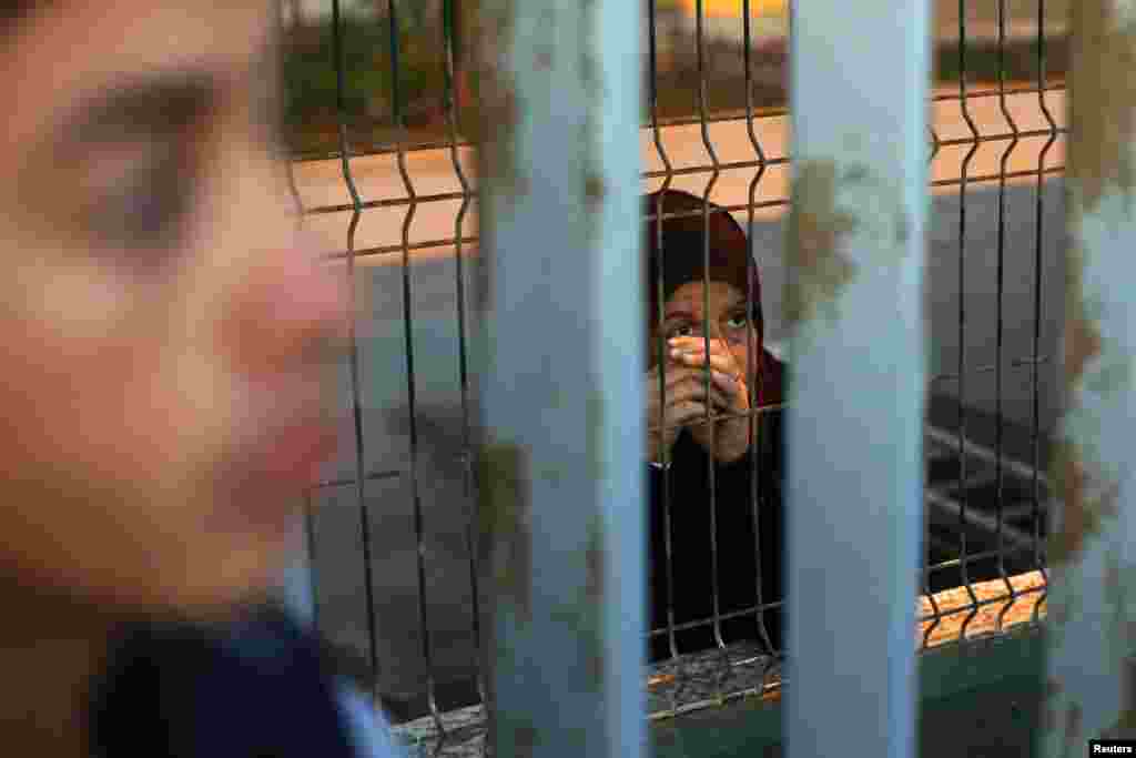 Syrian refugees from Latakia wait on opposite sides of a fence at a refugee center in Spain's north African enclave Melilla, Dec. 5, 2013.