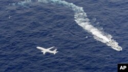 Un barco de la guardia costera de Japón y un avión militar estadounidense en la costa de Kochi, al suroeste de Japón, durante una operación de búsqueda y rescate tras un accidente de dos aviones militares estadounidenses.