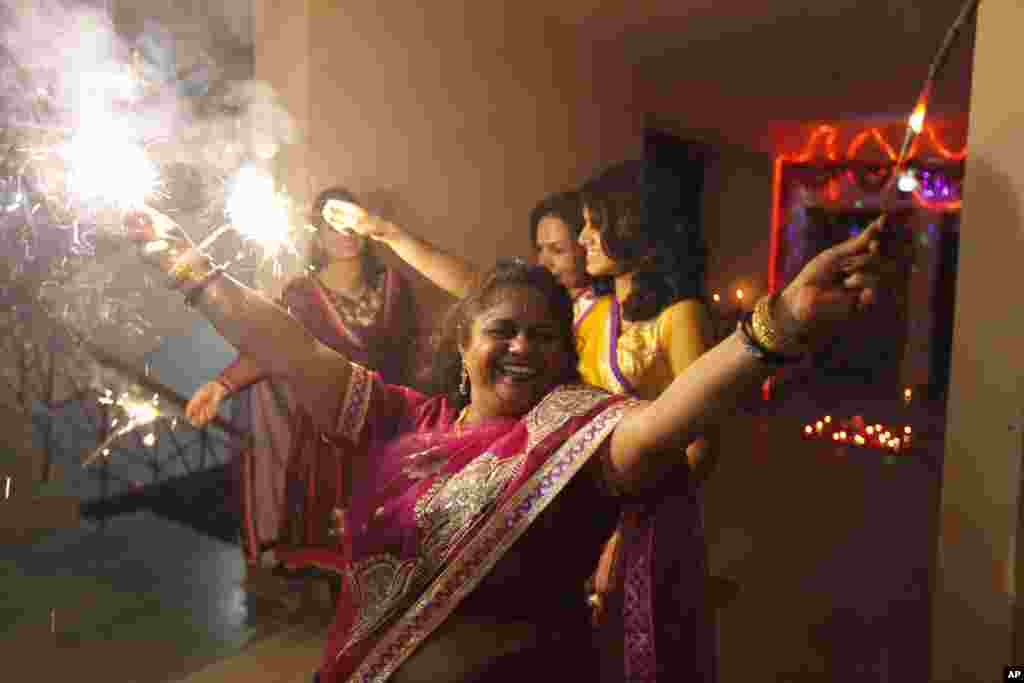 Para perempuan bermain kembang api dalam perayaan Diwali di Allahabad, India (3/11). (AP/Rajesh Kumar Singh)