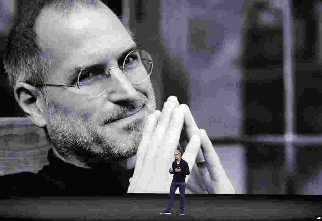 With a photo of former Apple co-founder and CEO Steve Jobs projected in the background, Apple CEO Tim Cook kicks off the event for a new product announcement at the Steve Jobs Theater on the new Apple campus in Cupertino, California.