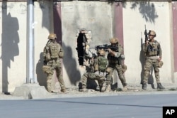 FILE - Afghan security personnel take positions near the Shamshad Television station after a deadly attack in Kabul, Afghanistan, Nov. 7, 2017, for which the Islamic State group claimed responsibility.