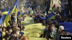 Protestors hold Ukrainian colors in a rally against Russian takeover of Crimea.