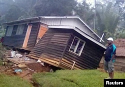 A local resident stands next to a damaged house near a landslide in the town of Tari after an earthquake struck Papua New Guinea's Southern Highlands, in this image taken Feb. 27, 2018, obtained from social media.