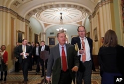 FILE - Senator Lindsey Graham walks with a reporter on Capitol Hill in Washington.