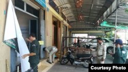 Police take down a banner outside an Adhoc office in Koh Kong province, Cambodia, Tuesday May 2, 2017. (Courtesty of Adhoc)