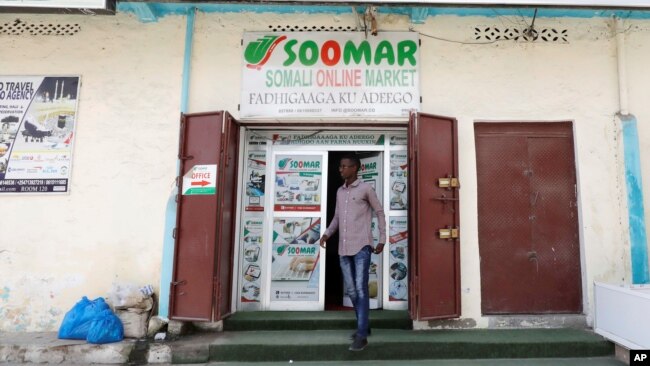 FILE - A customer walks out of the Somali Online Market (SOOMAR) offices at Maka Al Mukarama street in Mogadishu, Somalia, Oct. 17, 2018.