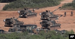 FILE - South Korean army K-55 self-propelled howitzers conduct a military exercise in Paju, South Korea, near the border with North Korea, Sept. 15, 2017.