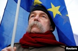 A man holds an EU flag as he takes part in a protest against a proposed new labor law, billed as the "slave law", in Budapest, Hungary, Jan. 19, 2019.