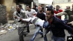 埃及人在开罗抬着在警民冲突中受伤者