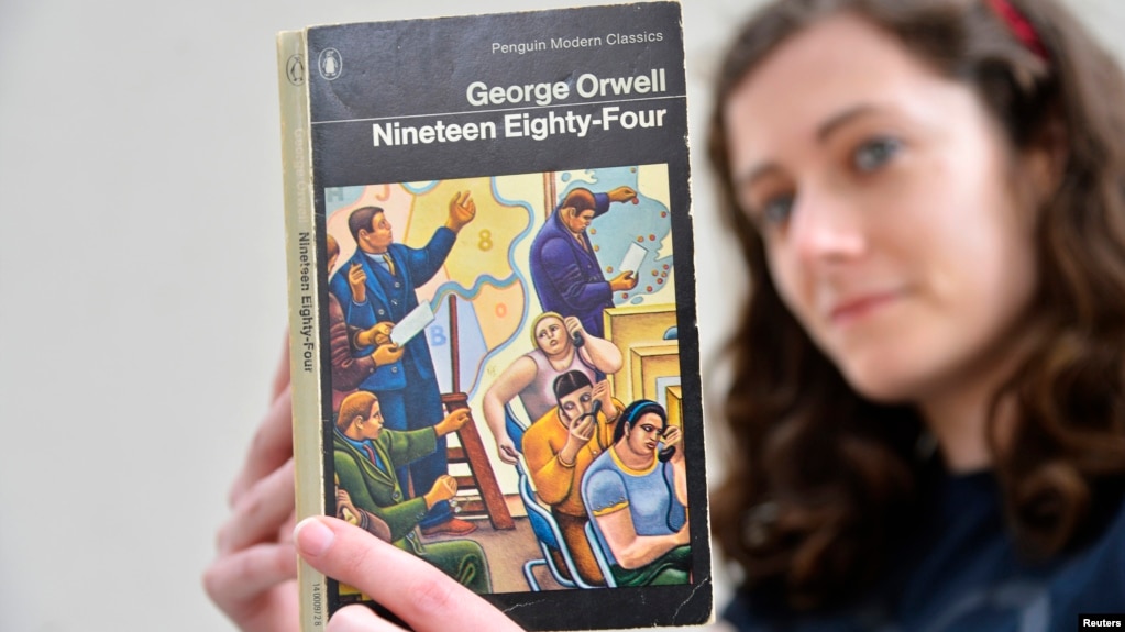 伦敦一家书店女职员手持英国作家乔治·奥威尔著作《1984》（路透社 2013年6月9日）(photo:VOA)