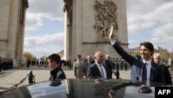 Le premier ministre canadien Justin Trudeau salue les spectateurs après une cérémonie de dépôt de gerbe sur la tombe du soldat inconnu à l'Arc de Triomphe, le 16 avril 2018.